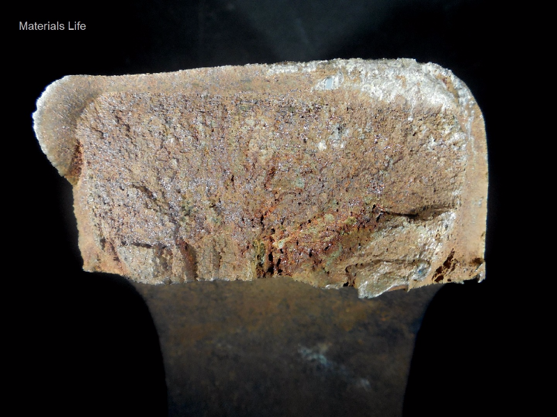 Aspect of the fracture surface, showing a brittle morphology.  Flat fracture with chevron marks from regions close to the internal diameter of the padeye, where there are secondary cracks.