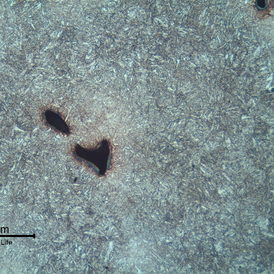 Micrography of the lifting padeye showing a quenched and tempered martensitic microstructure.  Voids are located in interdendritic segregated regions.