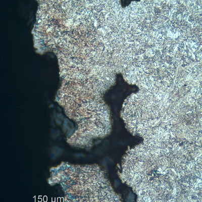 Micrographic detail of a region with a large amount of casting defects. Shrinkage voids in interdendritic spaces, some interconnected and cracked.