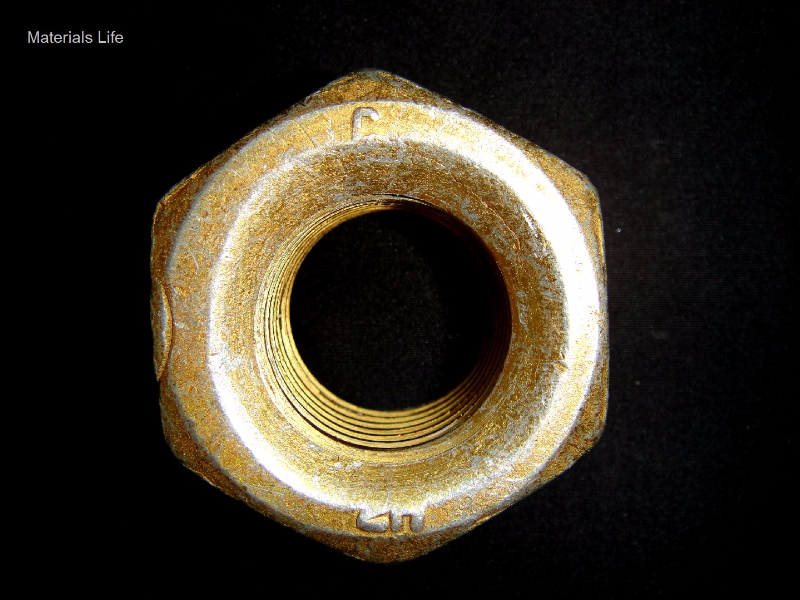 The general aspect of the 1 1/8" 2H nut, presenting rejectable indications that appear like cracks, located in the face and in the lateral side of the nut.