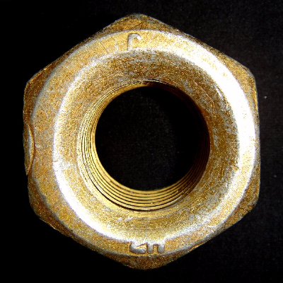 The general aspect of the 1 1/8" 2H nut, presenting rejectable indications that appear like cracks, located in the face and in the lateral side of the nut.