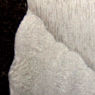 Macrography of the tubular forging, butt welded using a LAS filler metal, and overlaid using Inconel 625 filler metal. The micrographic characterization was conducted for the HAZ of the overlay and for the HAZ of the butt weld, at the root position (with several welding cycles) and at the face.