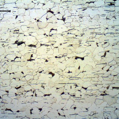 Micrography of the longitudinal section of the fitiing, in a free-cutting steel.  The microstructure is predominantly ferritic and there is a large amount of sulfide inclusions, aligned perpendicular to the forming direction.