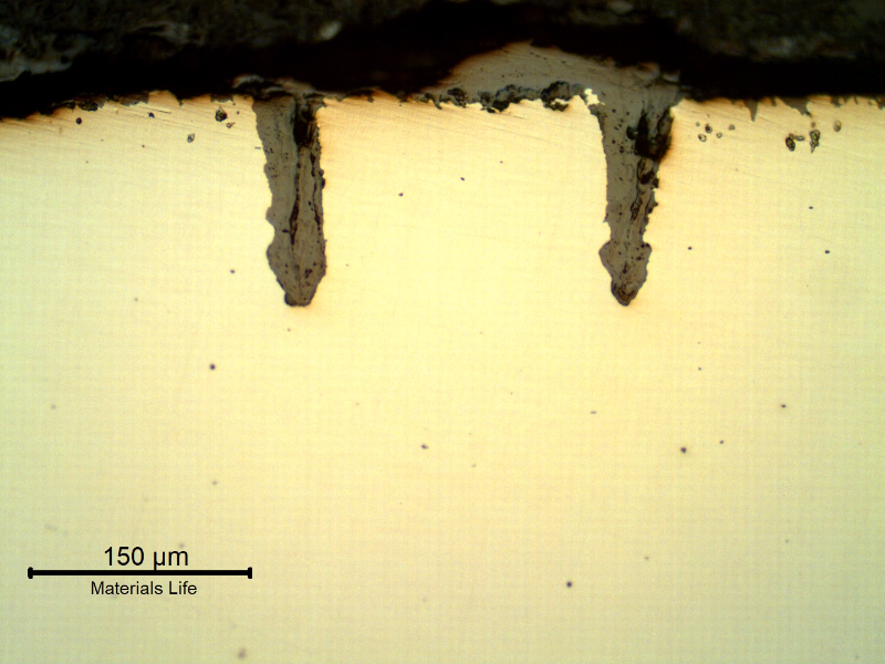 Micrographic details of the longitudinal section of the tube, close to OD, showing paralel cracks, filled with oxides, perpendicular to the surface.