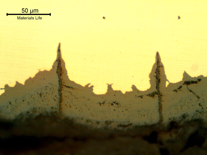 Micrographic details of the longitudinal section of the tube, close to ID, showing paralel cracks, filled with oxides, perpendicular to the surface.