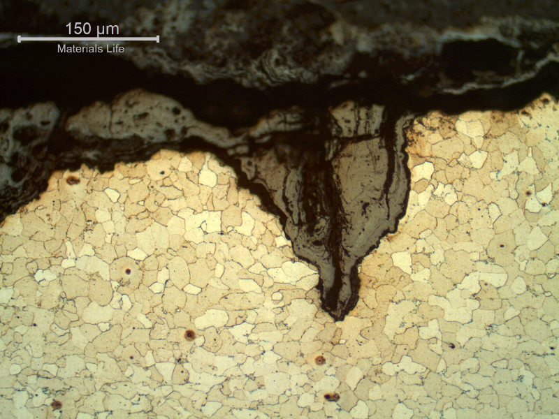 Micrography of the longitudinal section of the tube, close to OD, showing the cracks from the surface. The cracks are filled with oxides and slightly opened by corrosion.