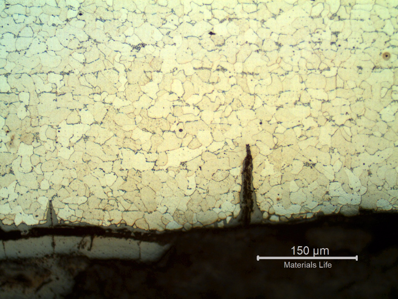 Micrography of the longitudinal section of the tube, close to ID, showing the cracks from the surface. The cracks are filled with oxides and there is still a layer of oxides at the internal surface, detached from the surface (probably during cleaning).