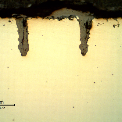 Micrographic details of the longitudinal section of the tube, close to OD, showing paralel cracks, filled with oxides, perpendicular to the surface.
