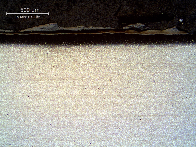 Micrography of the longitudinal section of the tube, close to the external surface. 
A scale  is evident at the surface as well as a carburizing layer.
