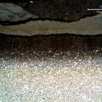 Micrography of the longitudinal section of the tube, close to the external surface. 
A scale  is evident at the surface as well as a carburizing layer.