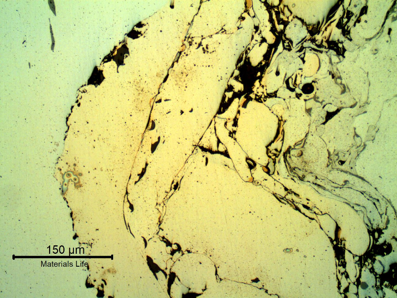 Micrographic detail, as polished in a longitudinal section, of the interface between the shaft substrate and the thermal spray layer.  In the left it is the shaft substrate also presenting parts of aligned inclusions (gray). In the center it is the Ni base TS alloy and in the right it is the Cr base TS alloy.  There are also black voids and grey oxides.