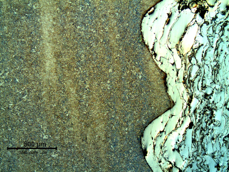 Micrography of the interface between the shaft surface and the thermal spray layer. The shaft steel presents a quenched and tempered structure. Longitudinal section.