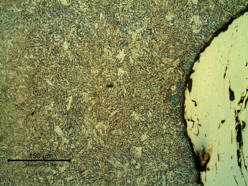 Micrographic detail of the interface between the shaft surface and the thermal spray layer. The shaft steel presents a quenched and tempered structure. Longitudinal section.