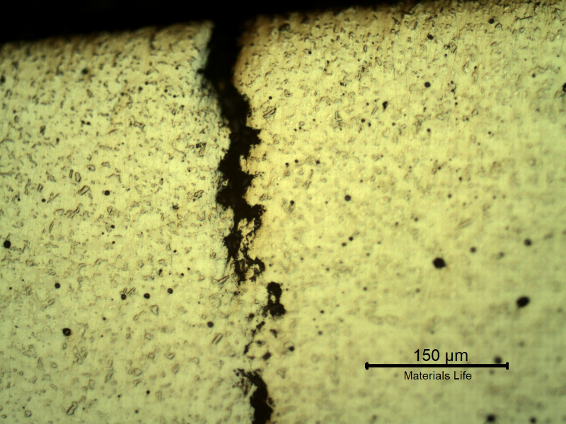Micrographic detail of the crack in the thermal spray layer. The spray and fuse layer presented a typically melted structure with entrapped pores and globular oxides.