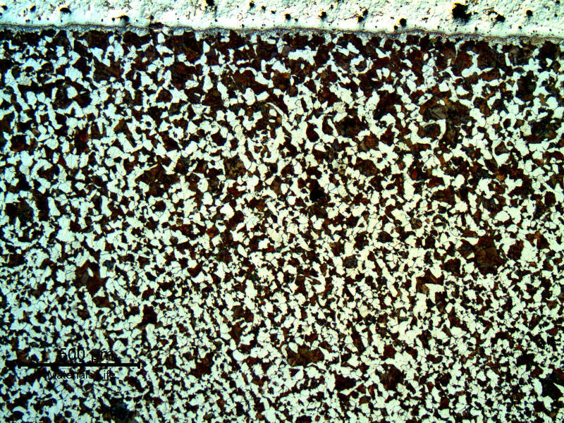 Low magnification micrography of the interface between the pin and the spray and fuse layer. Close to the surface, under the layer, the pin presents a ferritic perlitic structure, non conform with the high strenght requirement. Transverse section.