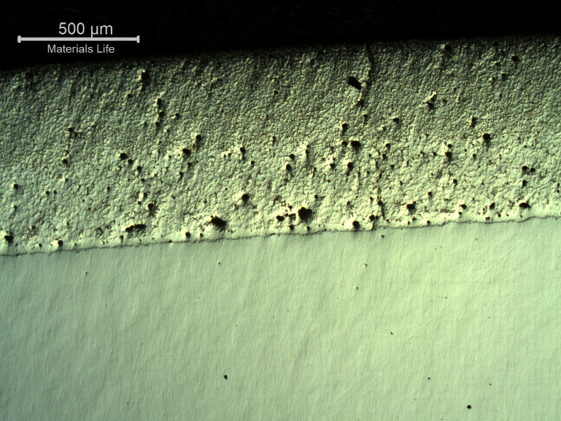 Micrography, as polished, of the transverse section of the forged pin with the layer applied by a (thermal) spray and fuse process. The layer presented entrapped pores and globular oxides. It was melted after application by thermal spray (in this case using a flame) but the pin was not heat treated after the full application and melting of the layer and the base metal is ferritc-pearlitic.