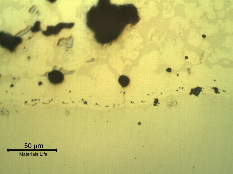 Micrographic detail, as polished, of the transverse section at the interface between the pin and the spray and fuse layer. The interface presents globular oxides and small pores, entrapped.