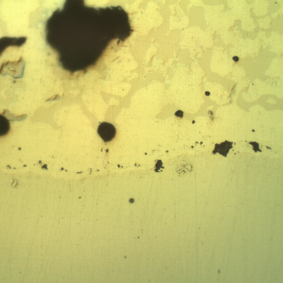 Micrographic detail, as polished, of the transverse section at the interface between the pin and the spray and fuse layer. The interface presents globular oxides and small pores, entrapped.