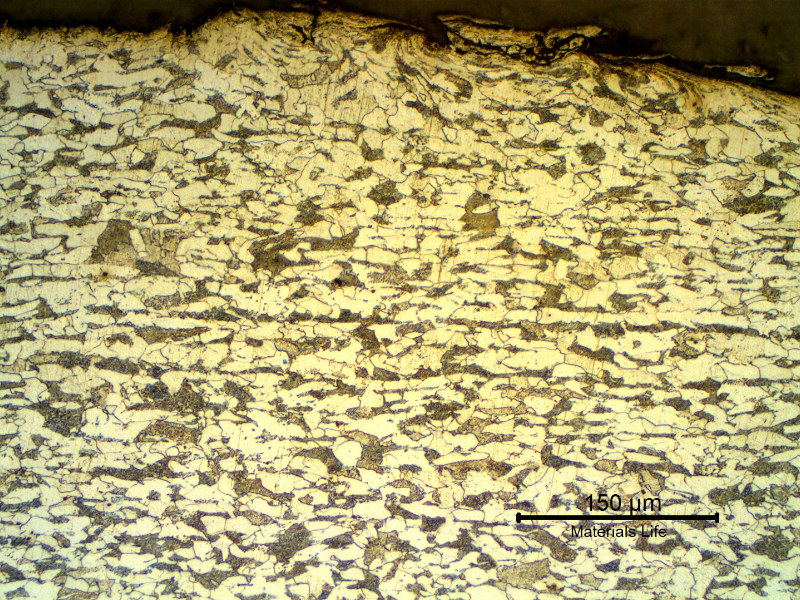 Micrographic detail of a transverse section of the tubing, at the external surface. Ferritic-pearlitic structure. The roughness of the surface is high because the structure was painted and a blasting treatment was probably applied to the surface to improve adherence.