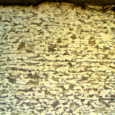 Micrographic detail of a transverse section of the tubing, at the external surface. Ferritic-pearlitic structure. The roughness of the surface is high because the structure was painted and a blasting treatment was probably applied to the surface to improve adherence.