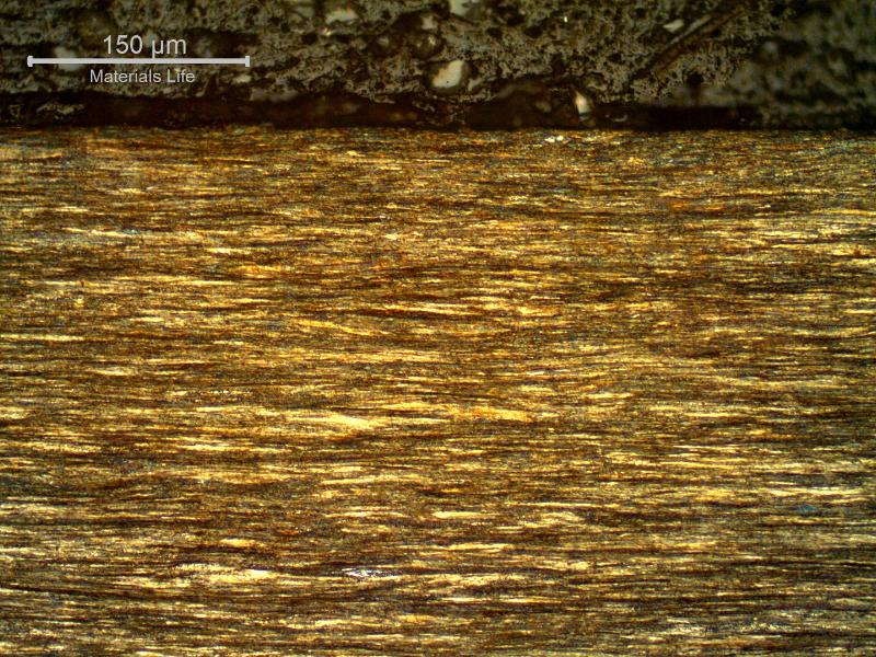 Micrography of a longitudinal section of the core wire, 2.0 mm diameter, at the surface of the wire, showing that the wire presents no protective layer (not galvanized) and the microstructure is strain hardened, aligned.