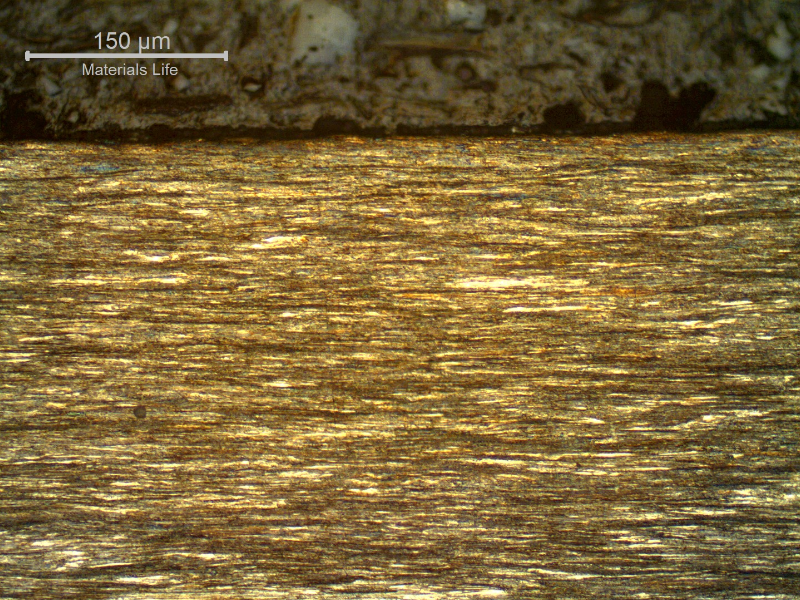 Micrography of a longitudinal section of the strand external layer wire, 3.8 mm diameter, at the surface, showing that the wire presents no protective layer (not galvanized) and the microstructure is strain hardened, aligned.