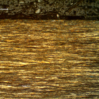 Micrography of a longitudinal section of the core wire, 2.0 mm diameter, at the surface of the wire, showing that the wire presents no protective layer (not galvanized) and the microstructure is strain hardened, aligned.