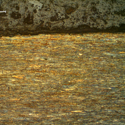 Micrography of a longitudinal section of the strand internal layer wire, 2.6 mm diameter, at the surface, showing that the wire presents no protective layer (not galvanized) and the microstructure is strain hardened, aligned.