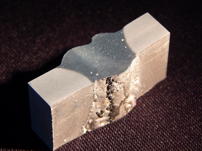The welded joint of the vertical up position is shown from the root side. It is possible to see that the use of the backing generated the possibility for melting the base metal out of the groove, without detection of this condition during welding, responsible for creating defects and avoiding the WPS qualification.