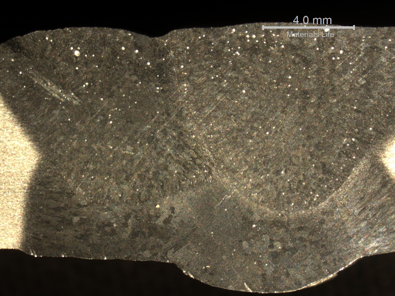 Macrographic detail of the flat position welded joint, showing the three passes. The large extension of the heat affected zone in the root reveals the too high imposed energy, melting out of the root gap. The shining spots are pores.