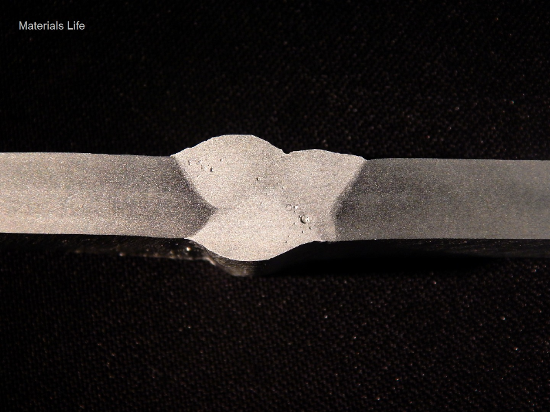 Macrography of the horizontal position joint. It was welded in three passes, and one additional pass from the root.   
Root pass - 153A, 20V, 156mm/s (wire speed), 3.5 mm/s (welding speed), 933 J/mm.  
Second pass - 162A, 20V, 156mm/s (wire speed), 5.8 mm/s (welding speed), 592 J/mm.  
Third pass - 155A, 19V, 156mm/s (wire speed), 5.9 mm/s (welding speed), 523 J/mm.  
Additional at the root - 161A, 23V, 187mm/s (wire speed), 8.5mm/s (welding speed), 467J/mm.