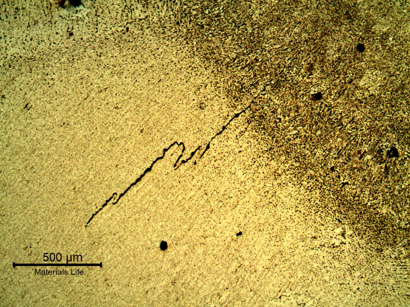 Micrography of the welded joint, at the root, presenting hot cracks.  The imposed high energy in the root due to the ceramic backing support created a condition for cracking.