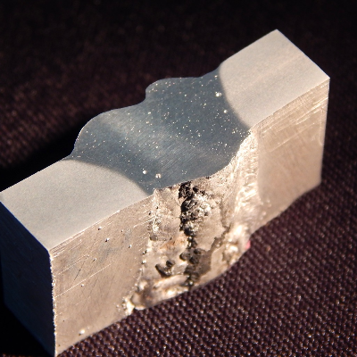 The welded joint of the vertical up position is shown from the root side.  It is possible to see that the use of the backing generated the possibility for melting the base metal out of the groove, without detection of this condition during welding, responsible for creating defects and avoiding the WPS qualification.