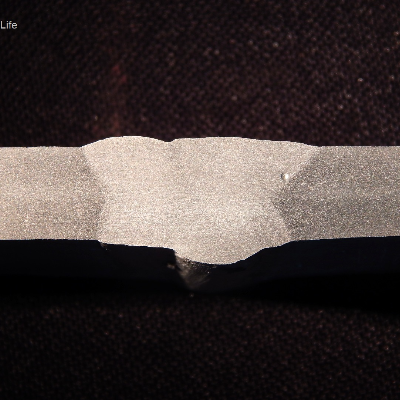 Macrography of the flat position welded joint. It was welded in three passes, with the following parameters.   
Root pass - 157A, 21V, 146mm/s (wire speed), 3.2 mm/s (welding speed), 1090 J/mm.  
Second pass - 161A, 21V, 146mm/s (wire speed), 4.2 mm/s (welding speed), 833 J/mm.  
Third pass - 155A, 21V, 146mm/s (wire speed), 5.1 mm/s (welding speed), 664 J/mm.