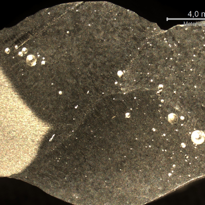 Macrographic detail of the horizontal position welded joint, showing the three passes welded from one side and the fourth pass welded after removing the ceramic backing.  Big pores and liquation were identified.
