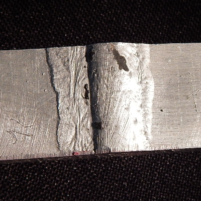 The welded joint of the flat position is shown from the root side.  It is possible to see that the use of the backing generated the possibility for melting the base metal out of the groove, without detection of this condition during welding, responsible for creating defects and avoiding the WPS qualification.