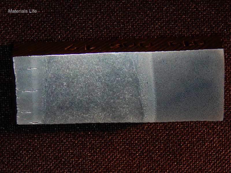 The macrography of the surface exposed to the combustion chamber presents multiple cracks, perpendicular to the internal diamater of the tube (left side of the figure).  The cracks are located in the tube and propagated into the tube wall and welded joint to the plate (right side of the figure).