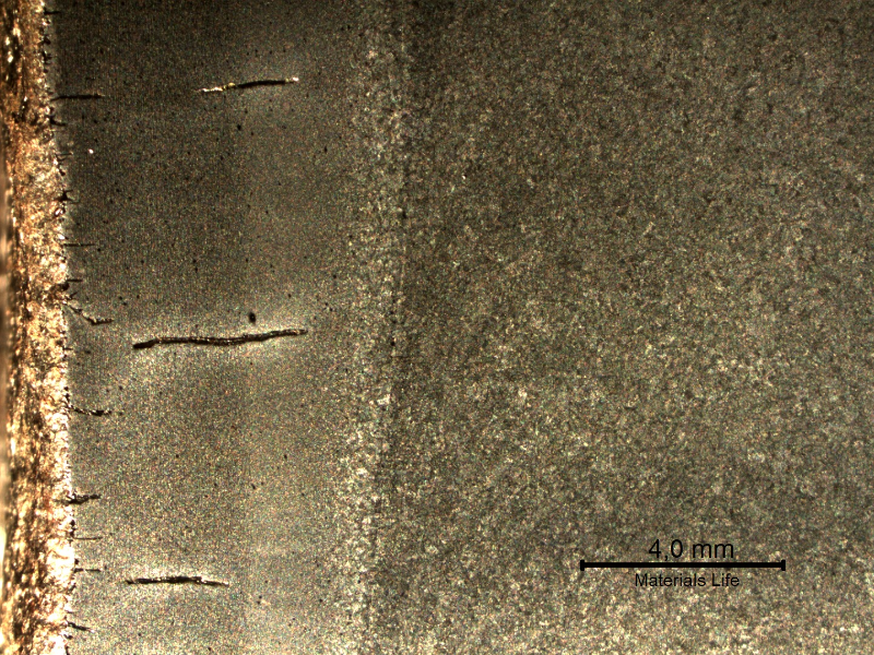Higher magnification macrography (in a stereoscope) of the surface exposed to the combustion chamber, presenting multiple cracks perpendicular to the internal diamater of the tube (left side of the figure).  The cracks are located in the tube and propagated into the tube wall and welded joint.