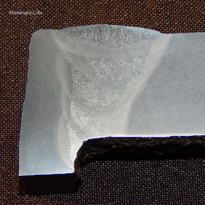 Macrography of the plate (thickness 22mm, in horizontal position) to tube (thickness 12.5 mm, in vertical position) welded joint. The half V groove was welded from the top (position inside the combustion chamber) in five weld beads, and with a small fillet welded from the water side (ouside of the tube). Average hardness of the plate is 180HV1 (1kg), of the tube is 150HV1 and of the weld is 190HV1. Maximum hardness of the tube HAZ is 165HV1 and plate HAZ is 195HV1.