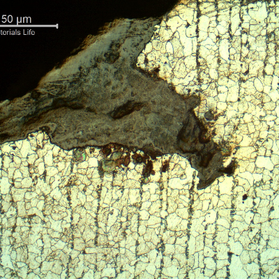 Micrographic detail of the crack at the edge of the tube.  This is not the best direction of analysis because the cracks are parallel to the analyzed section. It is possible to see the crack from the surface, large and filled with oxides.