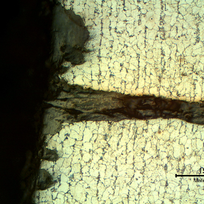 Micrography of the cracking surface, presenting multiple cracks from the edge of the tube, typical of fatigue induced by stresses generated by differential expansion of the pipe in relation to the tubesheet, due to thermal cycles.