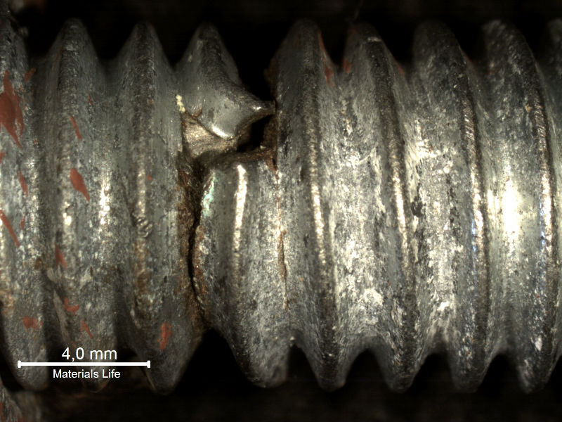 Detailed aspect of the eye bolt fracture position, with strong plastic deformation indicating ductile overloading. The red marks in the thread surface of the bolt (in the left side of the image) correspond to the position where the nut was tight. Thread fillets adjacent to the fracture presented secondary cracks.