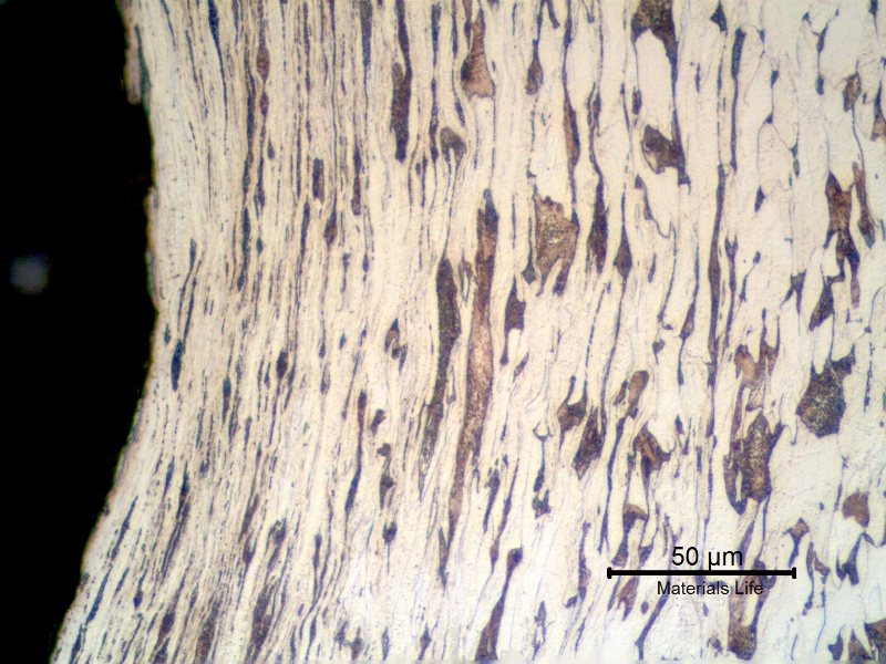 Micrographic detail of a longitudinal section of the bolt at the bottom of the thread fillet, presenting a plastically deformed ferritic pearlitic structure.  This analysis was conducted far from the failure and the structure was created by the cold forming process to manufacture the thread.