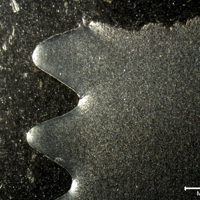 Macrography of a longitudinal section of the eye bolt, presenting the fracture in the top of the figure and the threads in the left side of the figure. Details of the fracture of the first thread fillet below the fracture are presented in the next figures.