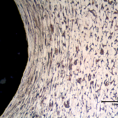 Micrography of a longitudinal section of the bolt at the bottom of the thread fillet, presenting a plastically deformed ferritic pearlitic structure in a very small extension from the surface (about 0.1mm). This analysis was conducted in a position far from the failure and the structure was created by the cold forming process to manufacture the thread.