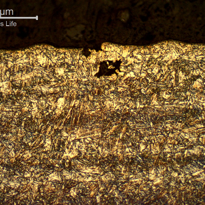 17-4 PH rod. Micrography of the longitudinal section close to the surface, presenting the roughness (the waves at the surface) and a region where a pitting was still in the beginning, not related to any specific microstructure.