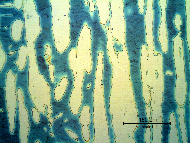 Micrography of a longitudinal section of the forged bar in the center of the thickness. Ferrite and austenite. The average austenite spacing is 80 microns, a lot larger than the maximum allowed in the specification, of 30 microns. No detrimental phases were identified at the ferrite/austenite interfaces, but the ferrite phase presented a rough aspect. Higher magnification analysis would be required to identify precipitation.