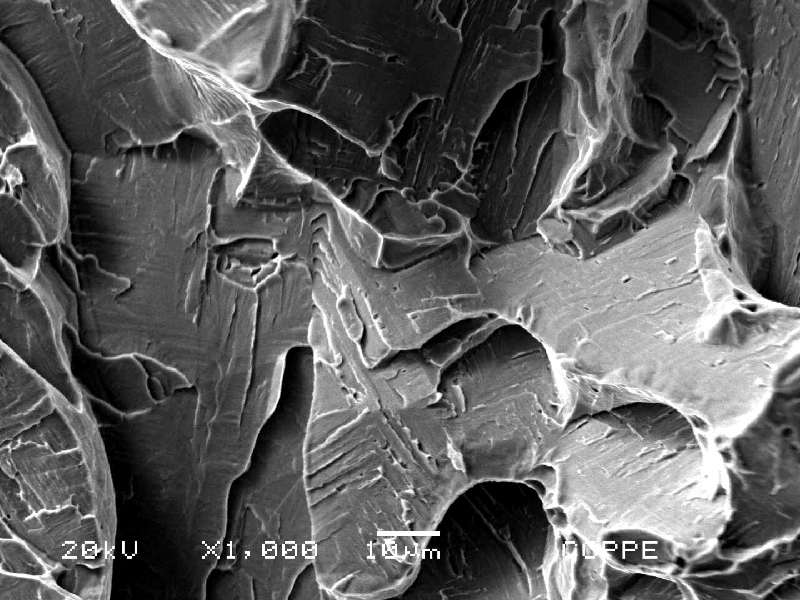 Fractographic detail of the longitudinal Charpy V testpiece,  broken at -46°C and presenting energy of 64J (the average energy of three tespieces was 70J).  The Charpy V testpiece was removed from the center of the bar. The micromechanism is quasicleavage and the test in this direction presented energy values superior than the minimum requirement of 45J.