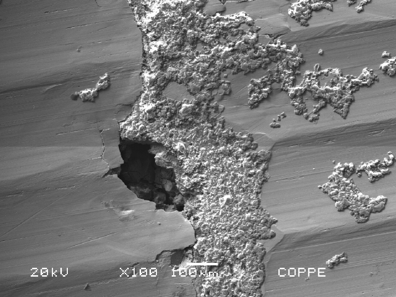 Microscopic details of the ring surface showing the fouling at the surface and localized corrosion under the deposits.