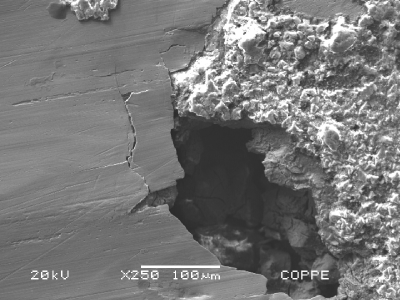 Higher magnification of the localized corrosion, showing that there are cracks at the margin of the corroded region.